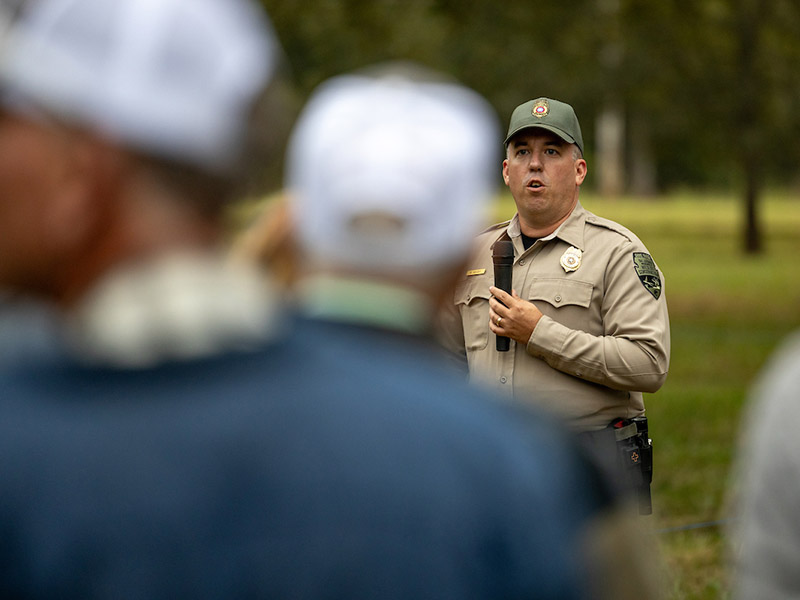 A wildlife officer talking to the native field day attendees.