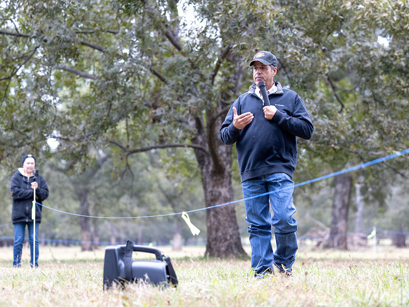 A man standing on the grass speaking at the 2023 Native Pecan Harvest Field Day.