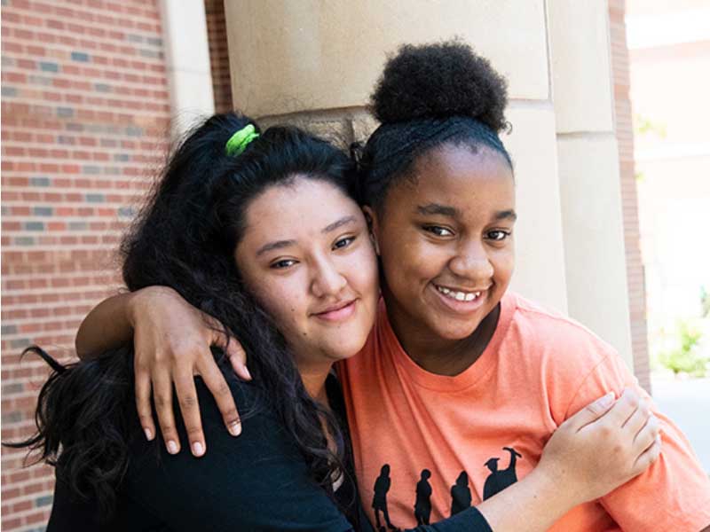 Two female students hugging.